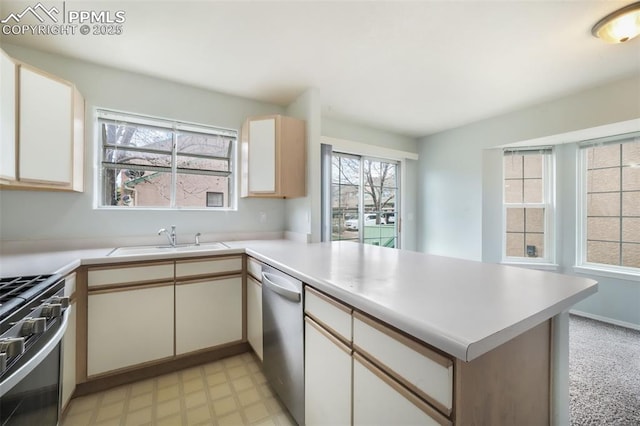 6142 Colony Cir, Colorado Springs, CO 80919 - kitchen with stainless steel appliances, a peninsula, a sink, light floors, and light countertops