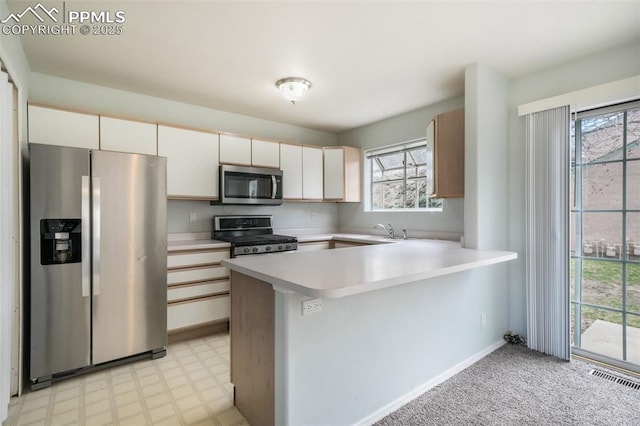 6142 Colony Cir, Colorado Springs, CO 80919 - kitchen featuring a sink, light countertops, a peninsula, appliances with stainless steel finishes, and visible vents