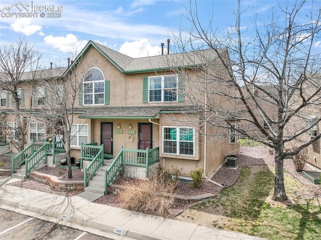 6142 Colony Cir, Colorado Springs, CO 80919 - view of front of home with a porch, roof with shingles, central AC, and stucco siding