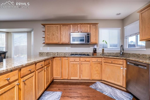 kitchen with a sink, dark wood-style flooring, open shelves, light stone countertops, and appliances with stainless steel finishes