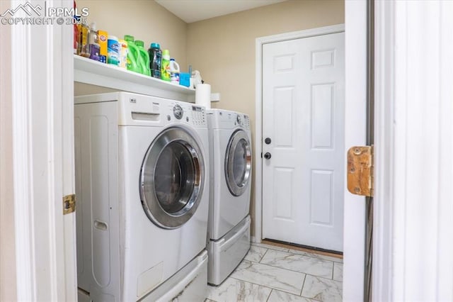 laundry room featuring washing machine and dryer, marble finish floor, and laundry area