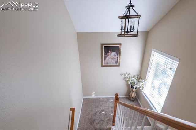 hall with carpet flooring, baseboards, and an upstairs landing