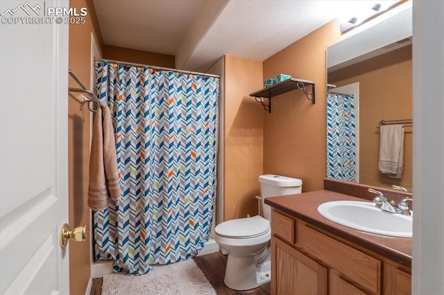 bathroom featuring a shower with curtain, wood finished floors, vanity, and toilet