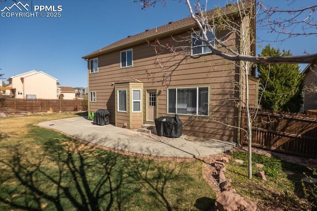 rear view of property featuring a fenced backyard, a yard, and a patio area