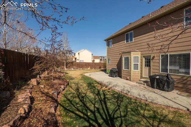 back of house featuring a fenced backyard, a patio area, and a lawn