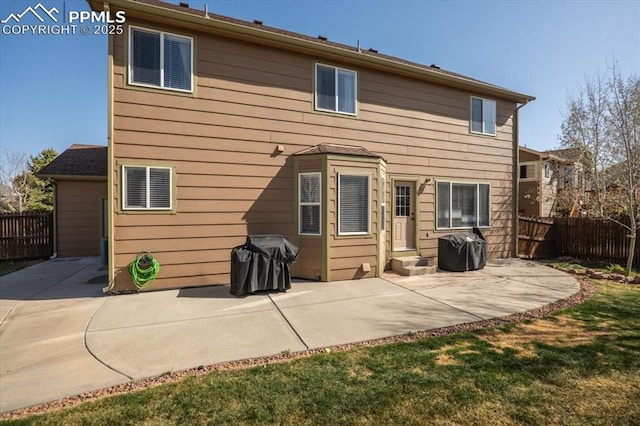 rear view of property featuring fence and a patio