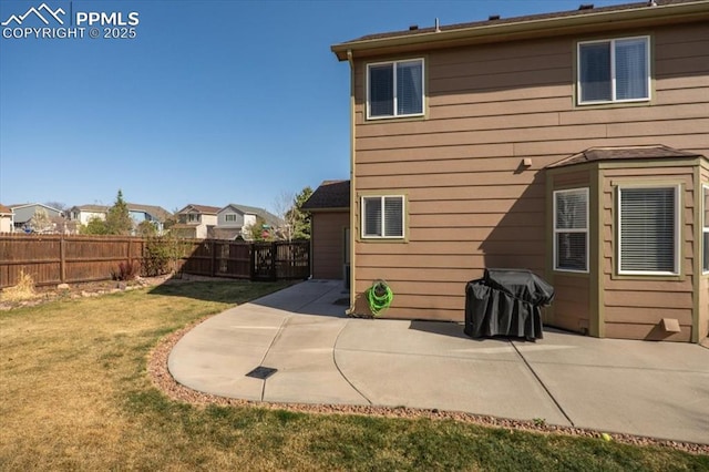 rear view of property featuring a lawn, a fenced backyard, and a patio