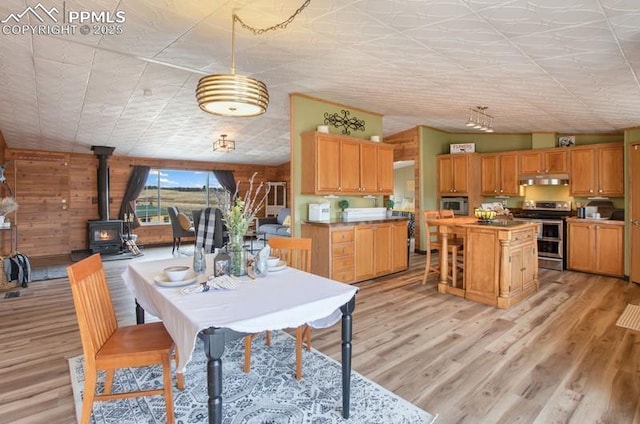 dining space with light wood-type flooring and a wood stove