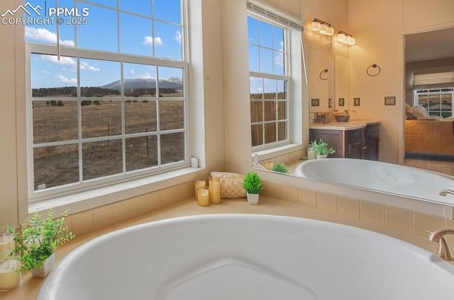 ensuite bathroom with a bath, vanity, connected bathroom, and a mountain view