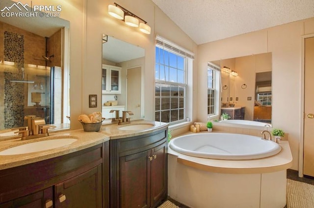 bathroom with lofted ceiling, a garden tub, a sink, and tiled shower