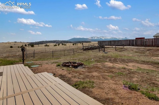 view of yard featuring fence, a rural view, and a mountain view