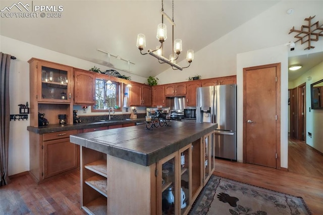 kitchen featuring stainless steel refrigerator with ice dispenser, vaulted ceiling, a sink, and dark wood-style flooring