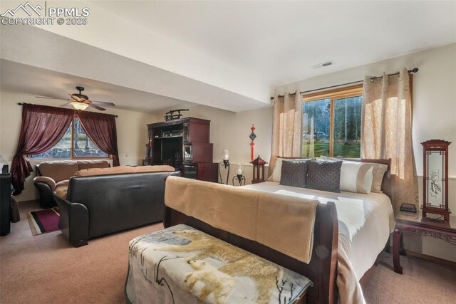 bedroom featuring light colored carpet, a ceiling fan, and visible vents