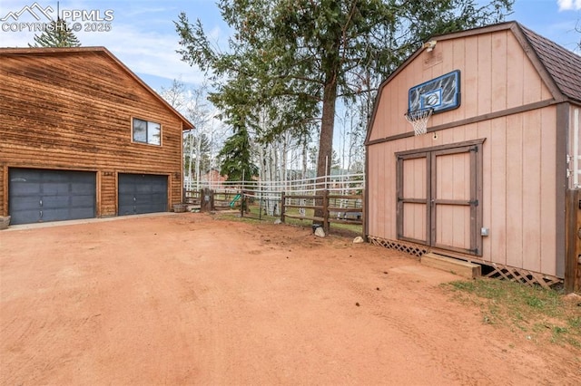 exterior space featuring fence and a detached garage