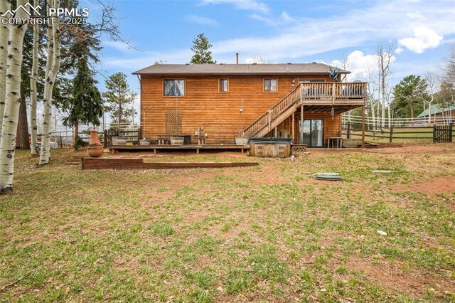 back of house featuring fence, a lawn, and a deck