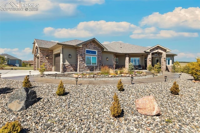 20356 Royal Troon Dr, Monument, CO 80132 - view of front of home with stone siding, an attached garage, stucco siding, and concrete driveway