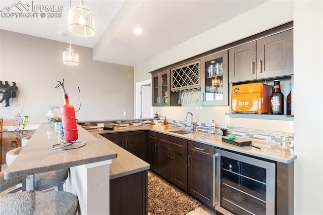 20356 Royal Troon Dr, Monument, CO 80132 - kitchen featuring wine cooler, a sink, a kitchen bar, decorative backsplash, and a peninsula