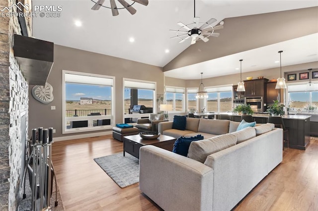 20356 Royal Troon Dr, Monument, CO 80132 - living room featuring ceiling fan, high vaulted ceiling, light wood finished floors, recessed lighting, and a stone fireplace