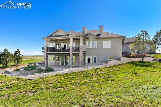20356 Royal Troon Dr, Monument, CO 80132 - rear view of house with a balcony, stucco siding, a patio, and a yard