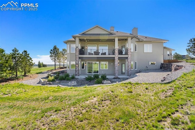 20356 Royal Troon Dr, Monument, CO 80132 - back of property with a balcony, stucco siding, a patio, a chimney, and a yard