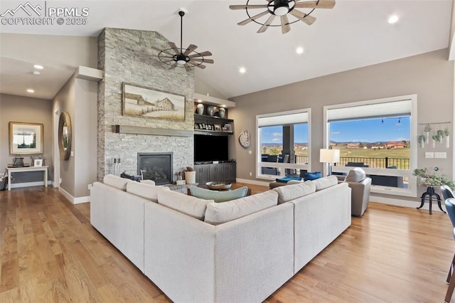 20356 Royal Troon Dr, Monument, CO 80132 - living area with ceiling fan, light wood-style flooring, baseboards, a fireplace, and high vaulted ceiling
