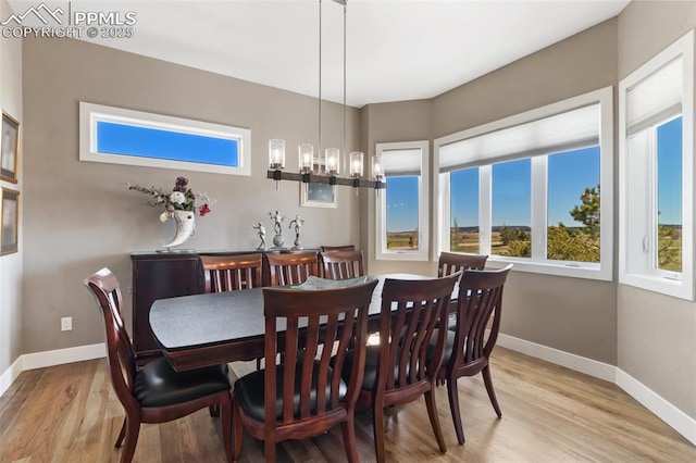 20356 Royal Troon Dr, Monument, CO 80132 - dining area with a chandelier, baseboards, and light wood-style flooring