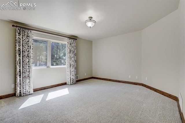 spare room with baseboards and carpet