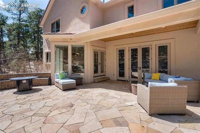 view of patio with an outdoor living space with a fire pit and french doors