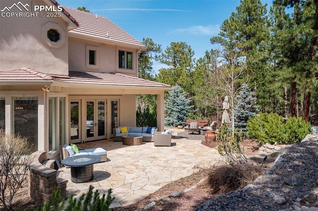 view of patio / terrace featuring french doors and an outdoor living space with a fire pit