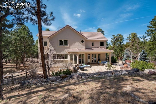 rear view of property with a patio area, a tiled roof, fence, stucco siding, and french doors