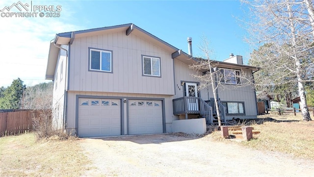 720 W Northwoods Dr, Woodland Park, CO 80863 - view of front of house with an attached garage, dirt driveway, a chimney, and fence