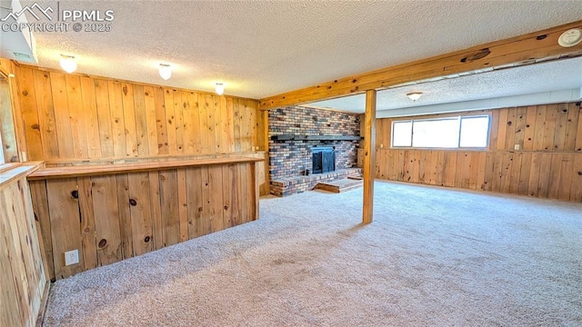 720 W Northwoods Dr, Woodland Park, CO 80863 - basement featuring a fireplace, carpet, a textured ceiling, and wood walls