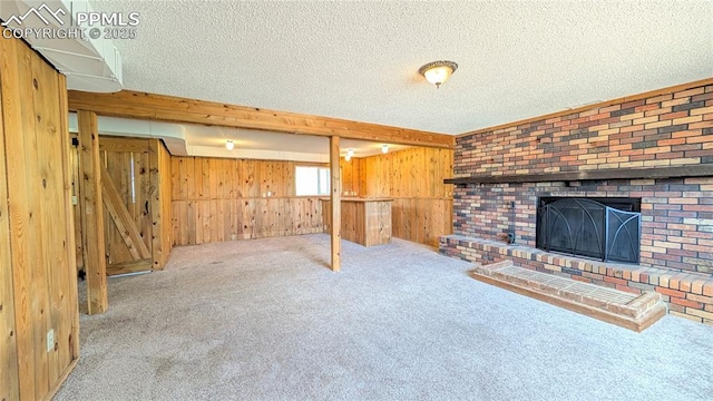 720 W Northwoods Dr, Woodland Park, CO 80863 - below grade area featuring a fireplace, a textured ceiling, wooden walls, and carpet