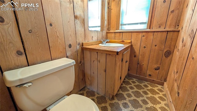 720 W Northwoods Dr, Woodland Park, CO 80863 - bathroom with wooden walls, vanity, and toilet