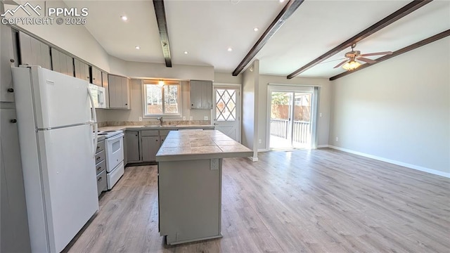 720 W Northwoods Dr, Woodland Park, CO 80863 - kitchen with a center island, a sink, white appliances, gray cabinetry, and beam ceiling
