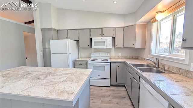 720 W Northwoods Dr, Woodland Park, CO 80863 - kitchen with a center island, a sink, light wood-style floors, white appliances, and gray cabinets