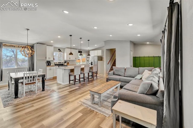 6465 Pawnee Cir, Colorado Springs, CO 80915 - living room featuring recessed lighting, light wood-type flooring, stairs, and a notable chandelier