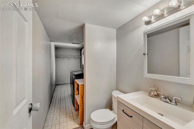 6465 Pawnee Cir, Colorado Springs, CO 80915 - bathroom featuring vanity, brick patterned floor, and toilet