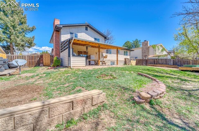 6465 Pawnee Cir, Colorado Springs, CO 80915 - rear view of house with a fenced backyard, a yard, and a chimney