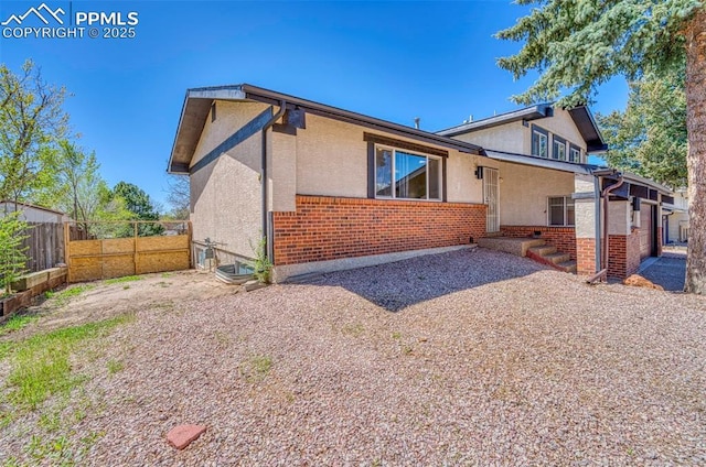 6465 Pawnee Cir, Colorado Springs, CO 80915 - rear view of house with stucco siding, fence, and brick siding