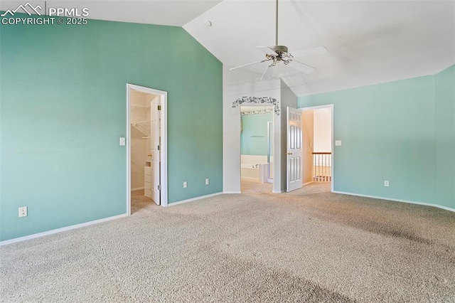6675 Cabin Creek Dr, Colorado Springs, CO 80923 - unfurnished bedroom with vaulted ceiling, baseboards, ensuite bathroom, carpet floors, and a walk in closet