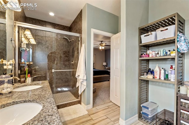 ensuite bathroom with a ceiling fan, ensuite bath, a sink, and a stall shower