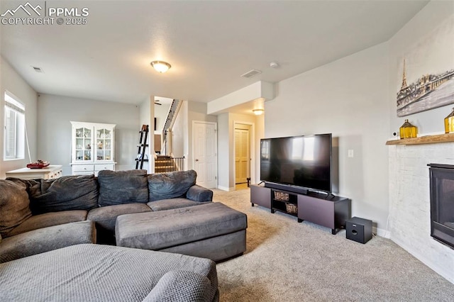 living area featuring baseboards, carpet flooring, stairs, and visible vents
