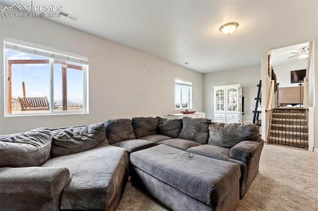 carpeted living area with a ceiling fan