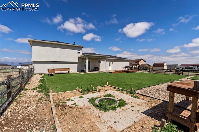 rear view of house with a yard, a patio, a fenced backyard, and stucco siding