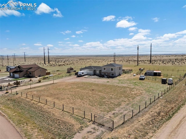 view of yard with dirt driveway, fence, and a rural view