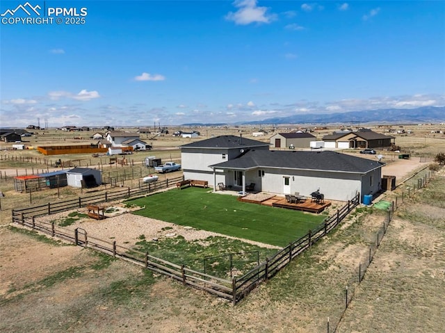 rear view of house with an outdoor structure, an exterior structure, fence, and a rural view