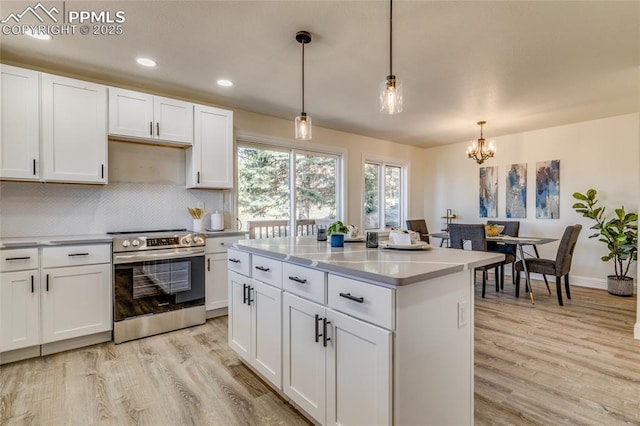 1120 Lake Woodmoor Dr, Monument, CO 80132 - kitchen featuring light wood-style floors, electric range, white cabinetry, a chandelier, and decorative backsplash