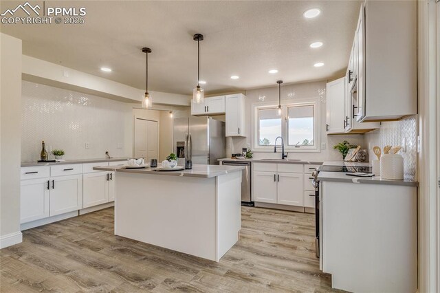 1120 Lake Woodmoor Dr, Monument, CO 80132 - kitchen with a sink, appliances with stainless steel finishes, recessed lighting, white cabinetry, and light wood-style flooring