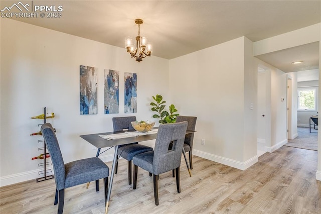 1120 Lake Woodmoor Dr, Monument, CO 80132 - dining area with light wood-style flooring, a chandelier, and baseboards